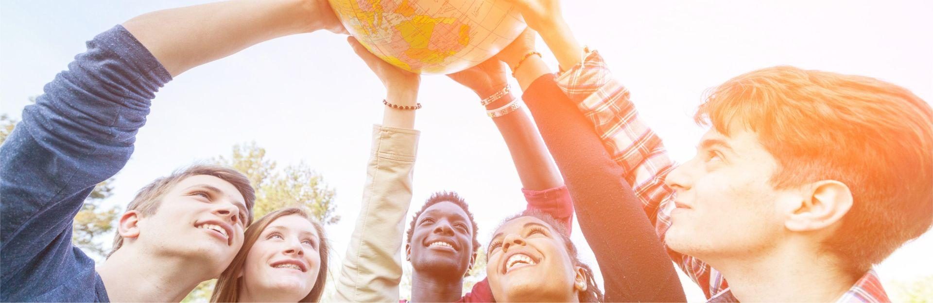 eine Gruppe von Studierenden hält Globus in die Höhe